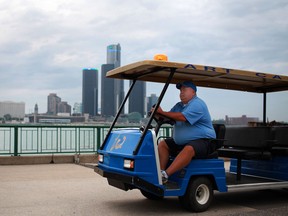 Jay Potts, the Art Cart Tour driver, waits for passengers to join him while at Windsor's riverfront in downtown Windsor, Friday, July 27, 2012.  The tour is free and takes passengers from the foot of Ouellette Avenue to the Ambassador Bridge and back, while explaining history, monuments, and the thirty plus sculptures at the sculpture garden.  (DAX MELMER/The Windsor Star)
