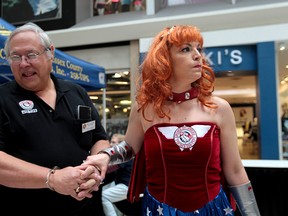Landy Justice takes Rene Jacques, past president of Windsor & Essex County Crime Stoppers, away in handcuffs at the 2014 Bail or Jail event at Devonshire Mall on Thursday, May 15, 2014. (DYLAN KRISTY/The Windsor Star)