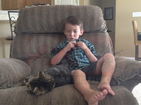 Jeremy, 4, sits beside the family cat, Tara, after she saved him from further attack on May 15, 2014 in Bakersfield, Calif., by the neighbour's dog. (23 ABC/Kero Bakersfield)