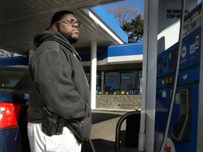 Greg Champion wears a gun while pumping gas in Detroit. To avoid becoming a carjacking victim, Champion wears a handgun on his hip whenever he’s pumping gas. Through May 19, Detroit has recorded 191 carjackings in 2014. (AP Photo/Carlos Osorio)