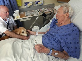 Jim Harris and his  Golden Retriever Kula visit Don Stratton a patient at the Met Campus of Windsor Regional hospital on Thursday, May 15, 2014. Harris has been a volunteer with the St. John Ambulance's dog therapy program for several years, making regular visits to local hospitals and senior centres.   (DAN JANISSE/The Windsor Star)