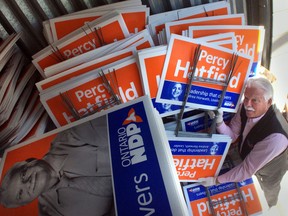 Percy Hatfield unloads campaign signs from a storage bin during preparation for the upcoming provincial election on May 6, 2014. (JASON KRYK/The Windsor Star)