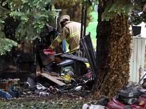 An investigator studies debris at the scene of a fatal house fire in Emeryville on May 28, 2014. (Tyler Brownbridge / The Windsor Star)