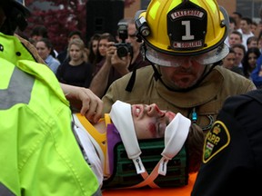 Student actor Anthony Giacalone is worked on by emergency crews as part of a Mock Drinking and Driving Accident Simulator, Wednesday. Emergency crews and student actors from St. Anne Catholic High School performed the presentation behind the school. The message is aimed at students with prom season right around the corner. (RICK DAWES/The Windsor Star)