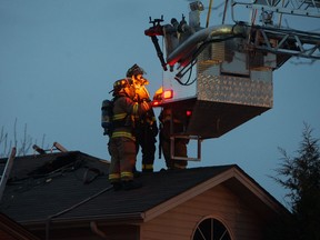 Firefighters stand on the roof of a house at 3312 Conservation Dr. on May 1, 2014. (Tyler Brownbridge / The Windsor Star)