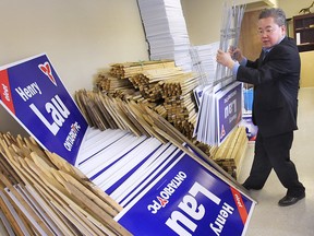 Henry Lau, PC Party candidate for Windsor West, readies his stacks of campaign signs on May 7, 2014. (Dan Janisse / The Windsor Star)