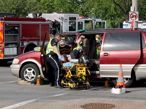 Emergency crews tend to injured motorists following a collision at the intersection of Howard Avenue and Edinborough Street, early Monday evening, May 19. Two vehicles were involved, the van and a red Dodge Ram 1500 pickup truck.  (RICK DAWES/The Windsor Star)
