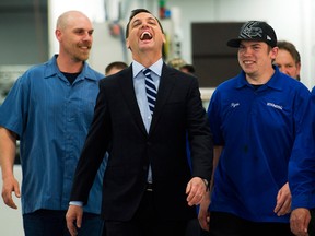 Ontario PC Party Leader Tim Hudak shares a laugh with workers at Stanpac Inc., a food packaging manufacturer, in the Niagara region on May 12, 2014. (Nathan Denette / The Canadian Press)