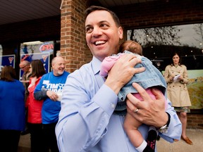Ontario PC Party leader Tim Hudak holds his baby daughter Maitland outside his campaign headquarters in Grimsby, Ont. on May 12, 2014. (Nathan Denette / The Canadian Press)