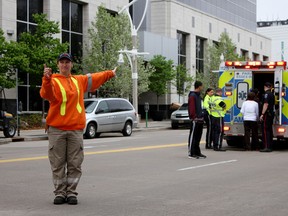 A city worker directs traffic following a collision between a vehicle and pedestrian in downtown Windsor on May 14, 2014. (Rick Dawes/The Windsor Star)