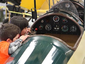 Siblings Matthew Mailloux, 5, and Emily, 6, peek inside the cockpit of a vintage plane on display at the Wings and Wheels event held at Windsor Airport on Saturday, May 3, 2014.  (REBECCA WRIGHT/ The Windsor Star)