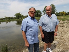 Bill Fellows, left, and Larry Brushett stand near the pond behind their condo building in Tecumseh on Monday, May 26, 2014. Fellow and Brushett would like to save the pond but a development is slated to fill it in.             (TYLER BROWNBRIDGE/The Windsor Star)