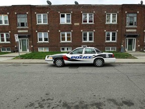 A Windsor Police car keeps an eye on the building where a shooting took place the night before in Windsor on Friday, May 9, 2014. (TYLER BROWNBRIDGE/The Windsor Star)