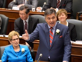 Ontario Finance Minister Charles Sousa (centre) delivers the 2014 provincial budget. Premier Kathleen Wynne (bottom left) and Windsor West MPP Teresa Piruzza (right) look on. Photographed May 1, 2014, at Queen's Park. (Nathan Denette / Canadian Press)