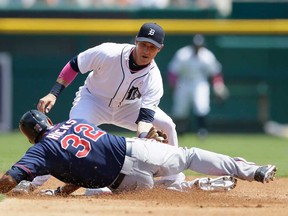 Tigers shortstop Andrew Romine, right, tags out Minnesota's Aaron Hicks on his steal attempt during the third inning in Detroit, Sunday, May 11, 2014. (AP Photo/Carlos Osorio)