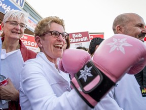 Premier Kathleen Wynne straps on a pair of boxing gloves at a campaign stop in Ottawa on May 7, 2014. (Justin Tang / The Canadian Press)