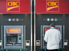 A man uses an ATM at a CIBC branch in Montreal, Thursday, April 24, 2014. (THE CANADIAN PRESS / Graham Hughes)