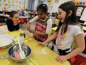 Hetherington Public School students Savanna Acchione-Barr, left, Esha Adeogun and Alyssa Hunter try their hand at making pancakes in class in Windsor. The students were practising for a Mother's Day breakfast. (TYLER BROWNBRIDGE / The Windsor Star)