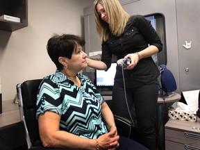 Lisa Macari, doctor of audiology at Hearing Wellness Centre, prepares a patient for a hearing test. (DAN JANISSE / The Windsor Star)