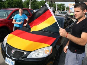 Kennedy student and Team Germany fan Jesse Talelli, right, displays a tradition window flag along with a full, hood-mounted flag across the front of his Pontiac. (NICK BRANCACCIO/The Windsor Star)
