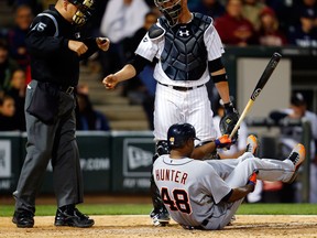 Detroit right-fielder Torii Hunter, right, falls after swinging at a pitch as Chicago catcher Tyler Flowers and umpire Jeff Nelson look on during the ninth inning in Chicago. (AP Photo/Jeff Haynes)