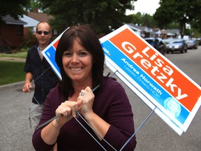 Newly elected Windsor West MPP Lisa Gretzky and her husband Tyler Gretzky, left, pick up lawn signs on Birch Street in west Windsor.  (NICK BRANCACCIO/The Windsor Star)