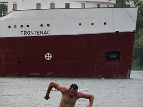 Matthew Harder cools off at Sandpoint Beach during a hot afternoon, Tuesday June 17, 2014.  Lifeguards were on duty, though only a few bathers got wet.  Behind, Canada Steamship Lines freighter Frontenac unloads crushed stone on lakefront. (NICK BRANCACCIO/The Windsor Star)