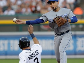 Former Tigers Omar Infante, right, throws to first base to complete a double play as Detroit's Ian Kinsler, left, tries to break it up on a Miguel Cabrera ground ball in the third inning. (AP Photo/Paul Sancya)