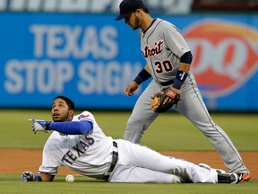 Texas Rangers' Elvis Andrus, left, was called out in front of Detroit shortstop Eugenio Suarez Tuesday  in Arlington. (AP Photo/Tony Gutierrez)