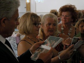 Windsor 50+ Singles Social Club members, from left to right, Steve Mitrevski, 70, Josie Dolinar, 62, and Jean Weir, browse over photos at the The Royal Canadian Legion on Marentette Avenue, Saturday, June, 28, 2014. The club was celebrating it's 18th anniversary. (RICK DAWES/The Windsor Star)