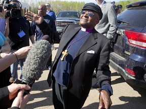 Archbishop Desmond Tutu hams it up for reporters after a helicopter ride to see the Alberta oil patch in Fort McMurray, Alta., on Saturday May 31, 2014. (Jason Franson/The Canadian Press)
