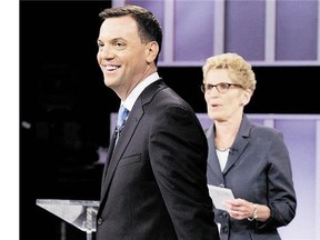 In this file photo, Ontario Progressive Conservative Leader Tim Hudak, left, laughs next to Ontario Liberal Leader Kathleen Wynne, right, after taking part in the live leaders debate in Toronto recently. (Frank Gunn/The Canadian Press)