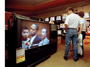 In this June 20, 1994 file photo, mall shoppers in Tampa, Fla., watch banks of televisions in an electronics store as the arraignment of O.J. Simpson is televised from Los Angeles. The O.J. Simpson trial was labeled the Trial of the Century and a forerunner of today's interactive media. (Associate Press files)