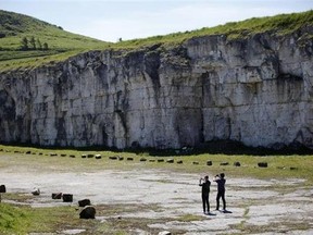 In this photo taken June 13, 2014, tourists take photographs of the North Antrim Coast close to Carrick-a-Rede Rope Bridge lies Larrybane headland. Larrybane was the dramatic spot chosen for Renly Baratheon's camp in Season 2 of Game of Thrones. (AP Photo/Peter Morrison)