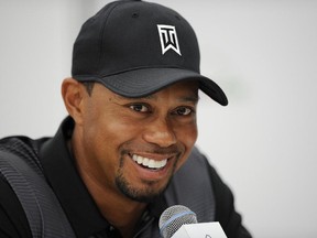 Tiger Woods smiles at a press conference at the Quicken Loans National golf tournament, Tuesday, June 24, 2014, in Bethesda, Md. (AP Photo/Nick Wass)