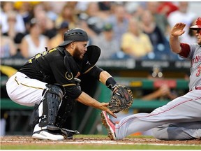 Devin Mesoraco #39 of the Cincinnati Reds slides safely into home plate in front of Russell Martin #55 of the Pittsburgh Pirates during the third inning on June 18, 2014 at PNC Park in Pittsburgh, Pennsylvania. (Joe Sargent/Getty Images)