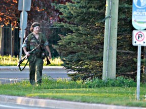 A heavily armed man that police have identified as Justin Bourque walks on Hildegard Drive in Moncton, New Brunswick, on Wednesday, June 4, 2014, after several shots were fired in the area. (AP Photo/The Canadian Press, Moncton Times & Transcript, telegraphjournal.com, Viktor Pivovarov)