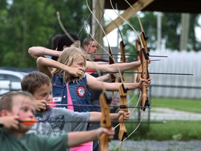Jadelyn Lacroix, 10, centre, joins other children as they practice archery at the Windsor Sportsmen Club, Thursday, June 26, 2014.  (DAX MELMER/The Windsor Star)