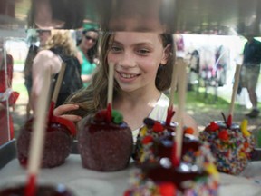 Madelon Kidd, 9, takes a look at the caramel apples on sale at Bruce County Nut and Fudge at Art in the Park, Saturday, June 7, 2014.  (DAX MELMER/The Windsor Star)
