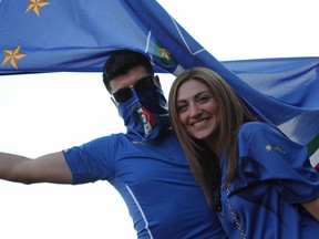 Italy fans, Alex Carbonaro, 28, left, and Stephanie Evola, 23, pose for a photo Saturday, June 14, 2014, on Erie Street East in front of Vesta Pizzaria & Antipasto Bar. Crowds formed in the street after Italy beat England 2-1. (RICK DAWES/The Windsor Star)