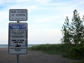 A sign warning swimmers to keep an eye on weather conditions and "swim at your own risk" is pictured on June 29, 2014 in Erieau, Ont. The body of a 14-year-old boy was recovered from Lake Erie Sunday morning after he went missing the night before. (RICK DAWES/The Windsor Star)