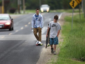 Luke Digiovanni, 17, left,  and Daniel Milling, 14, friends of Andrew "Drew" Gyorgy are shown Monday, June 2, 2014, near the site where the 16-year-old was killed Friday night. He was hit by a car while pushing a dirt bike along the narrow shoulder on County Rd. 50. (DAN JANISSE/The Windsor Star)
