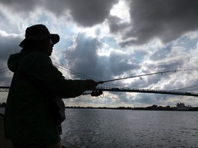 A fisherman casts a line into the Detroit River in this June 2014 file photo. (JASON KRYK/The Windsor Star)