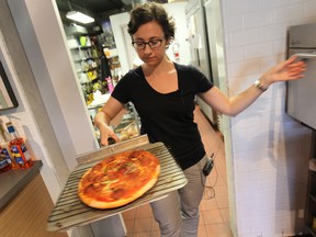Windsor Star food writer Beatrice Fantoni takes a frozen pizza out of the over.  (DAN JANISSE/The Windsor Star)