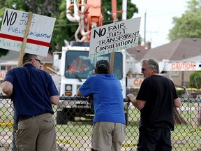 From left to right, Steve Wilson, David Calus and Jim LeBlanc watch construction crews at the the location of the new fire station #2, June 6. Located at the corner of Chandler Road and Milloy Street, residents said they believe adding a fire station at this location could be unsafe due to the regular neighborhood traffic congestion. (RICK DAWES/The Windsor Star)