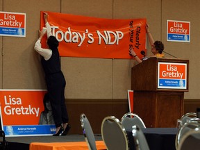 In this file photo, NDP campaign volunteers hang signs as they wait for the polls to close at the Caboto Club in Windsor on Thursday, June 12, 2014.               (Tyler Brownbridge/The Windsor Star)