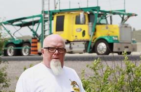 Jim Ingersoll stands in the backyard of his Tecumseh, Ontario home as truck traffic passes along the Herb Gray Parkway on June 17, 2014. (JASON KRYK/The Windsor Star)