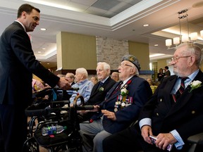 Ontario PC Party leader Tim Hudak unsuccessfully tries to shake the hand of Second World War veteran Ross Baker in Toronto on June 6, 2014. (Nathan Denette / The Canadian Press)