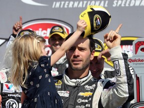 Jimmie Johnson's daughter Genevieve takes his cap off in Victory Lane after the NASCAR Quicken Loans 400 auto race at Michigan International Speedway in Brooklyn, Mich., Sunday, June 15, 2014. (AP Photo/Bob Brodbeck)