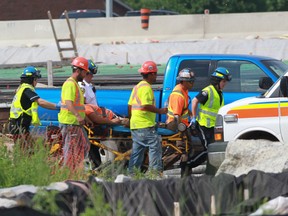 Emergency crews transport a conscious and alert worker from from a separate incident near where another worker was killed in LaSalle, Ontario on June 17,2014. The Ontario Provincial Police are investigating the industrial accident. (JASON KRYK/The Windsor Star)